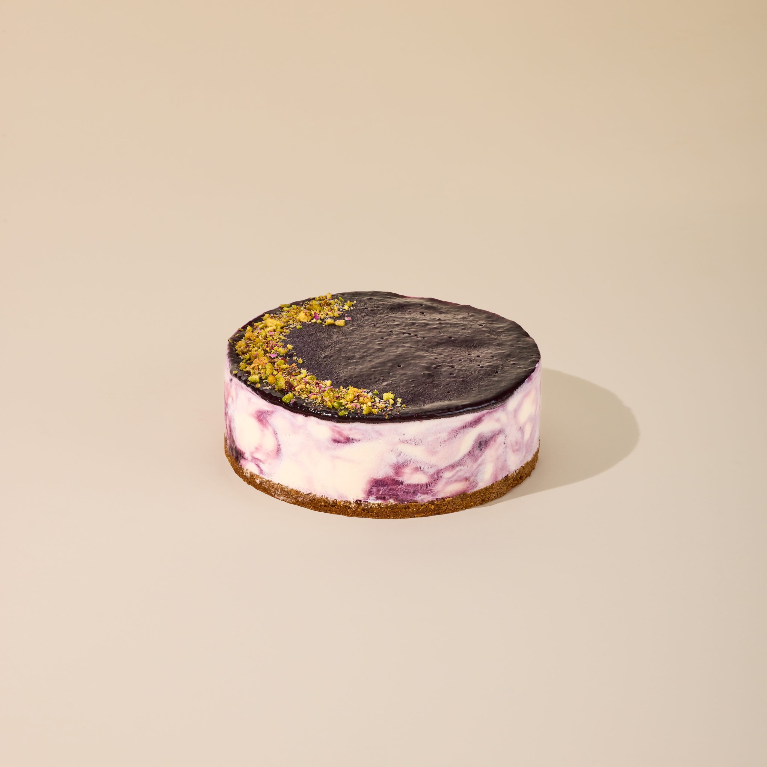 Blueberry swirl cheesecake ice cream cake with dark chocolate glaze on a graham cracker crust, halal certified