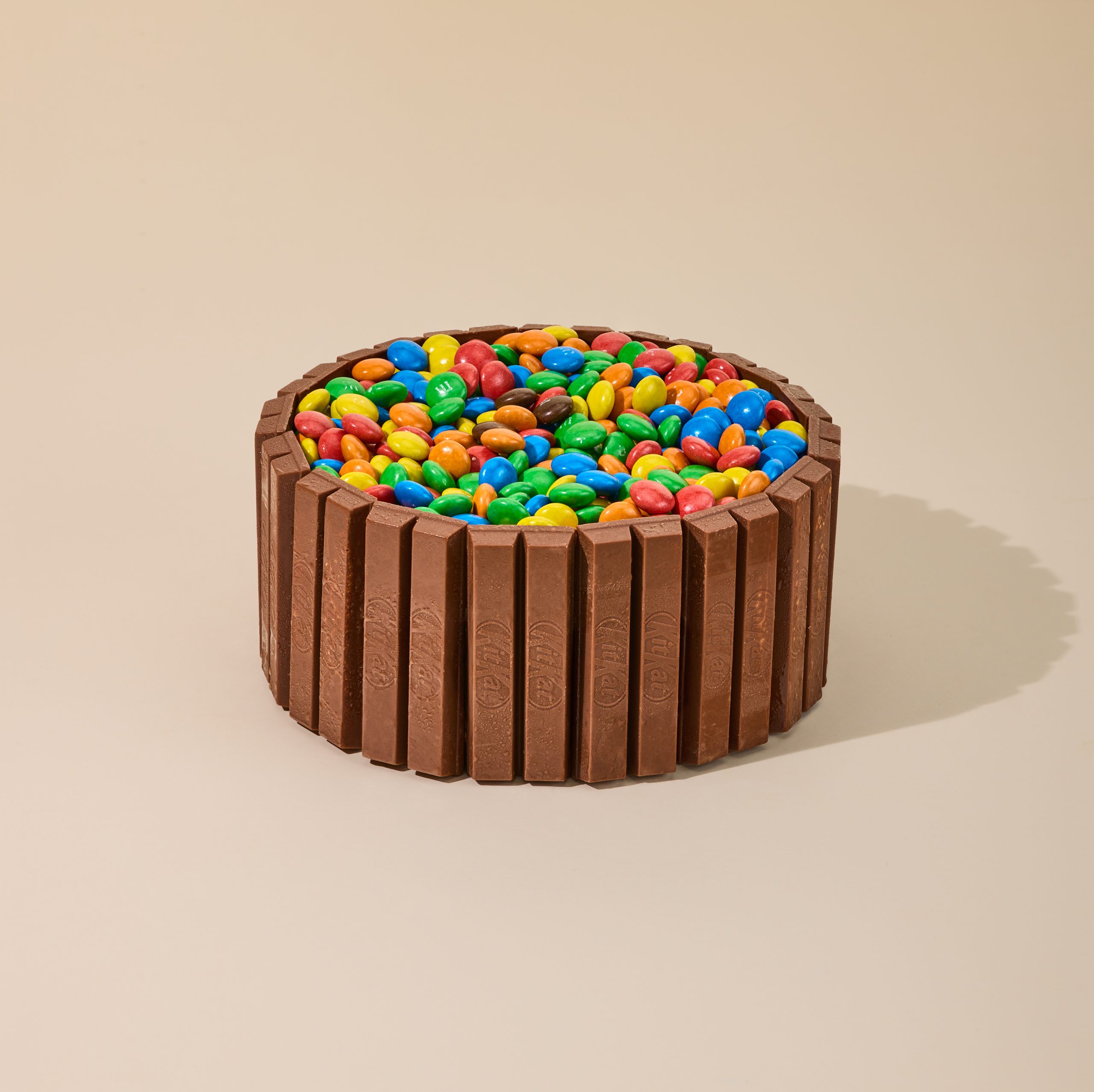 Ice cream cake wrapped in chocolate wafer bars with a colourful candy-coated chocolate topping