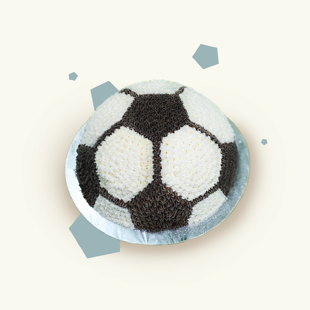 Dome-shaped football ice cream cake decorated with black and white piped cream rosettes in a soccer ball pattern